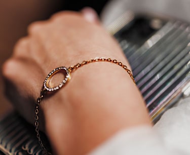 A row of gold and silver bracelets laid out on the velvet counter.
